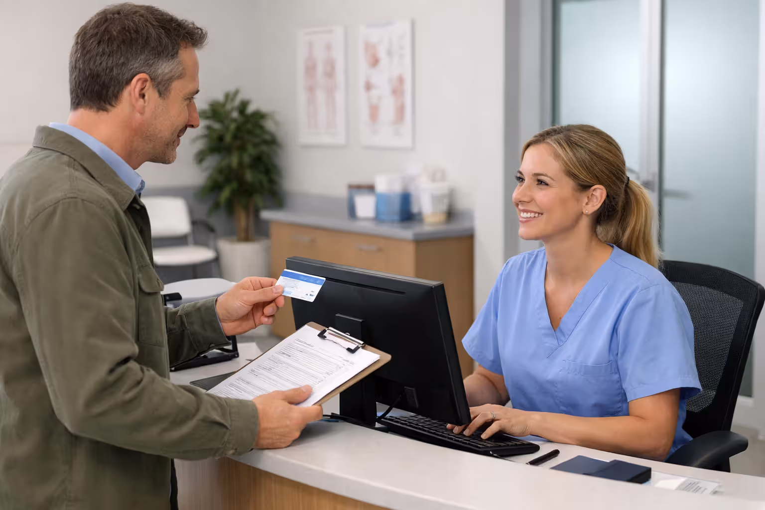 Patient submitting insurance information at a clinic reception desk