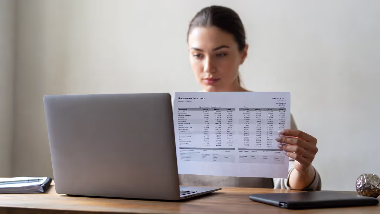 Person comparing multiple homeowners insurance quotes at a desk
